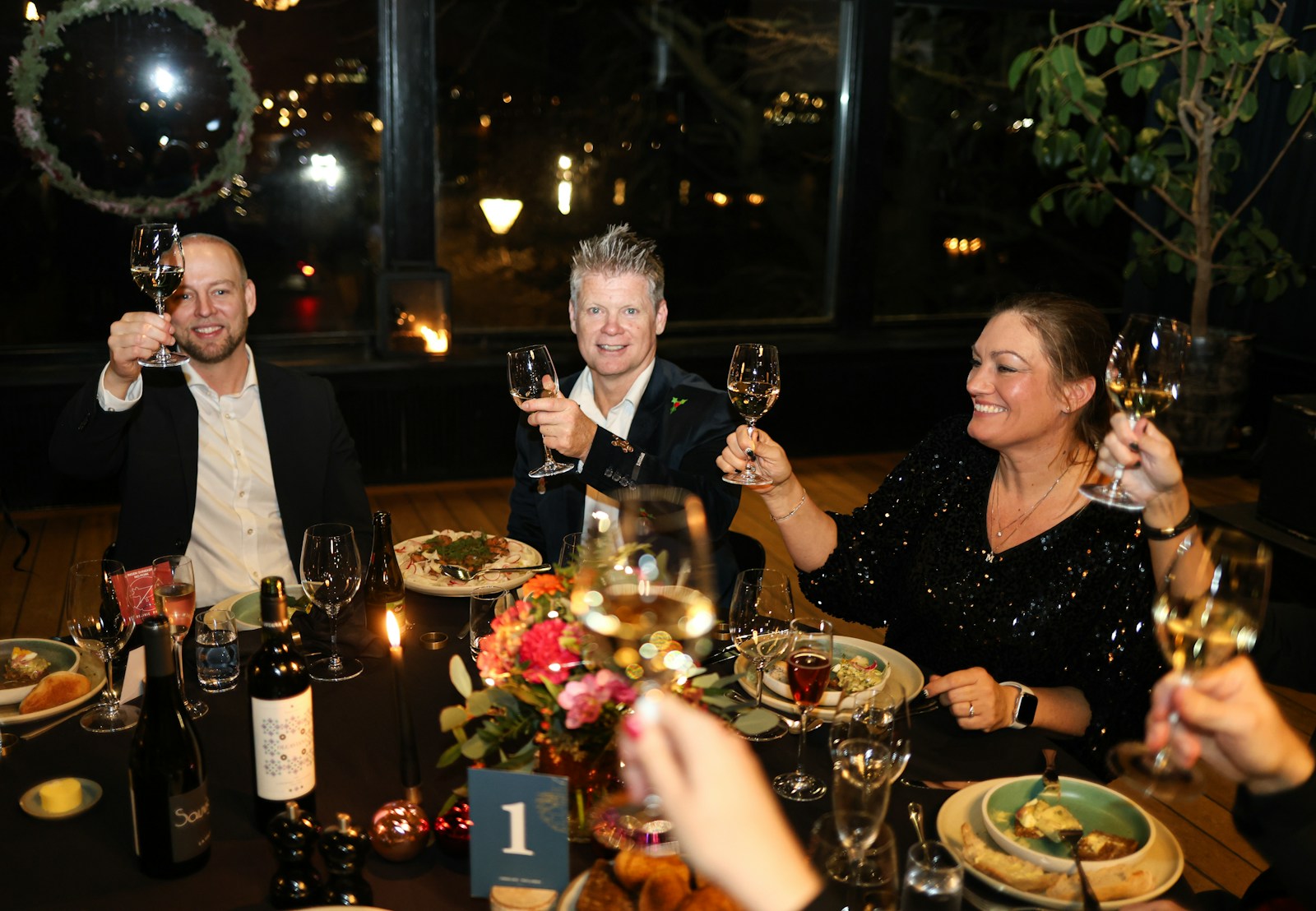 Pessoas brindando com taças de vinho durante um jantar